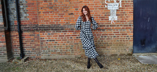 women wearing check midi dress by wall