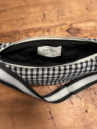 Black and white checkered bag with visible brand label on a wooden surface