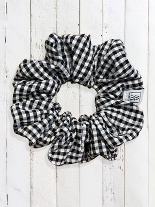 Black and white checkered scrunchie on a wooden surface