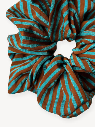 Turquoise and brown striped scrunchie on a white background