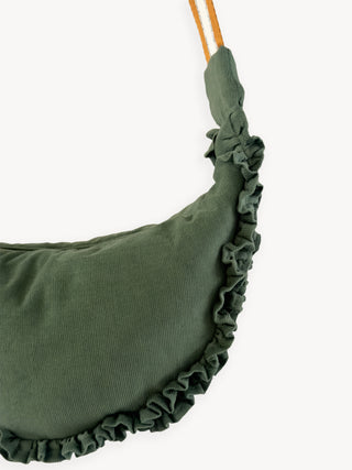 Green cushion with ruffled edge on a white background