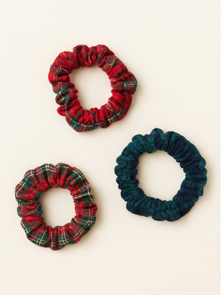 Three plaid scrunchies in red, green, and blue on a white background