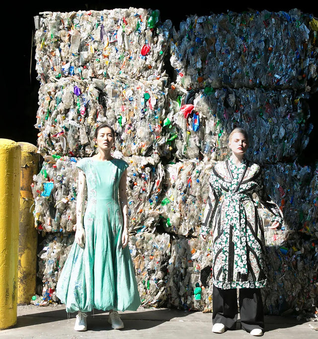 women stood by textiles destined for landfill