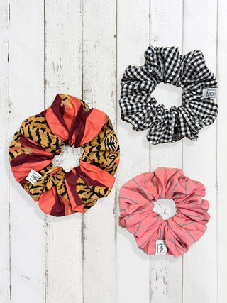 Three patterned scrunchies on a wooden surface