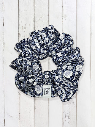 Navy floral scrunchie on a white wooden background