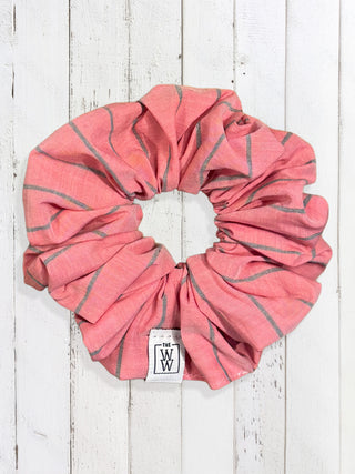 Pink and gray striped shower cap with a visible brand logo on a white wooden background