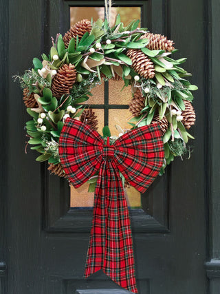 Christmas wreath with plaid bow on a door