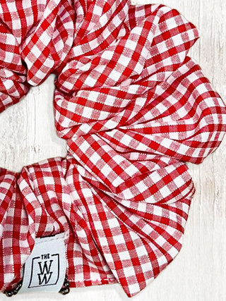 Red and white checkered fabric with a visible brand logo on a light wooden surface