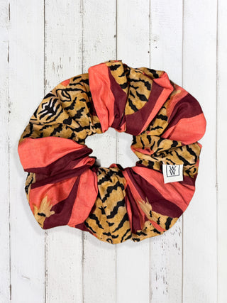 Colorful scrunchie with animal print pattern on a white wooden background
