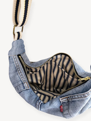 Denim bag with striped lining on a white background