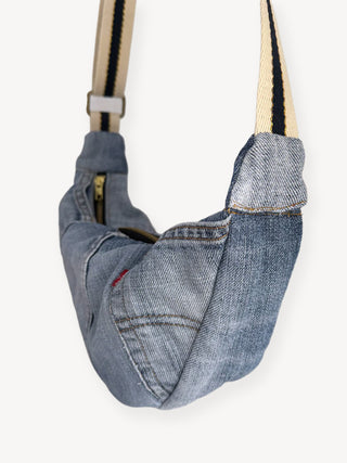 Denim bag with a strap on a white background