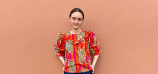 Model wearing The Well Worn ruffle blouse in tiger print made from deadstock cotton with bold orange and pink stripes