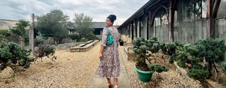 Woman in floral midi dress from The Well Worn’s Remade Collection, ethically made in the UK from deadstock fabric.