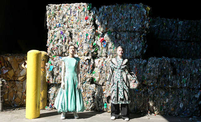 women stood in front of landfill clothes