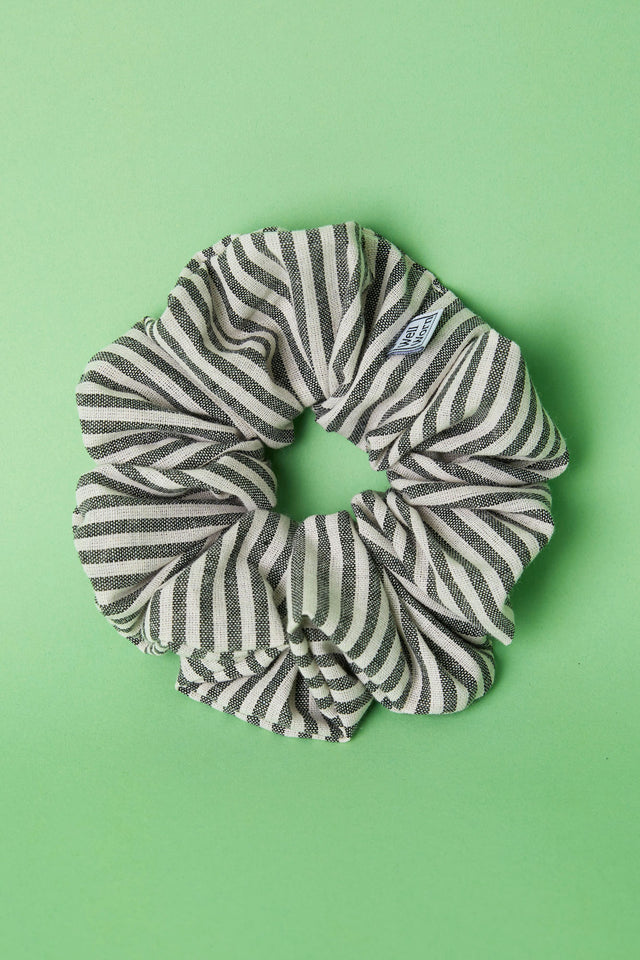 The Well Worn stripe scrunchie on green background