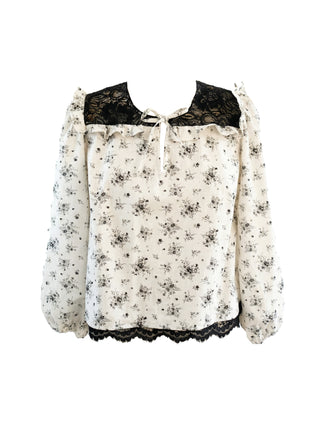 White blouse with black lace details on a white background