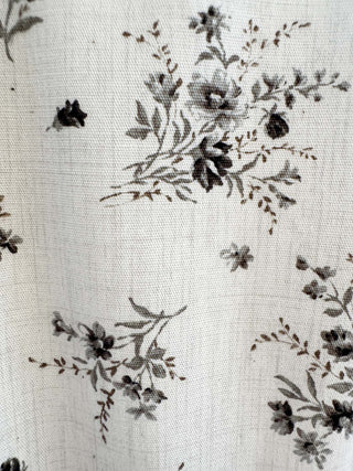Floral pattern on fabric with black flowers and leaves on a white background