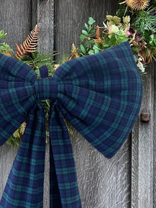 Blue plaid bow on a decorative wreath against a wooden background