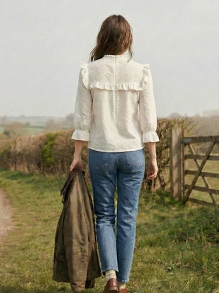 model wearing ruffle top in countryside