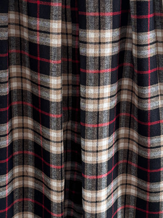 Close-up of plaid fabric with black, red, and beige colors.
