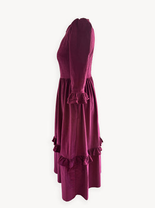 Burgundy dress with ruffled details on a white background