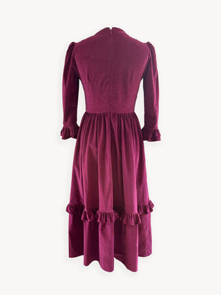 Burgundy dress with ruffled details on a white background