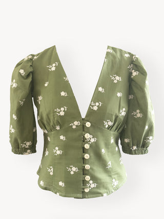 Green blouse with floral pattern on a white background