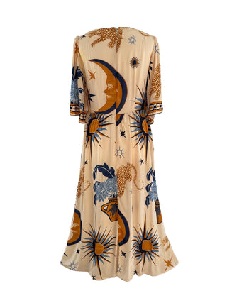 The Seraphina Dress with a celestial print, featuring a v-neckline, flutter sleeves, and a flowy midi skirt in golden and navy tones.