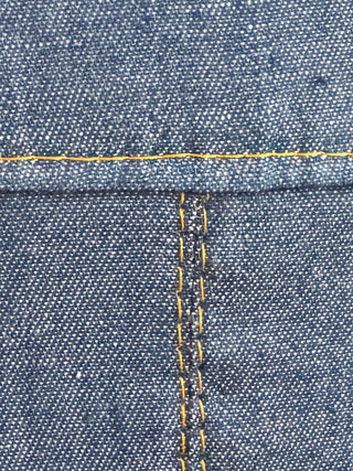 Close-up of a blue denim fabric with a visible seam.