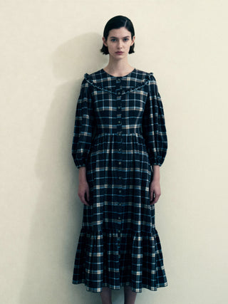 Woman wearing a black and white plaid dress against a plain background