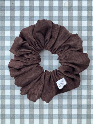 Brown scrunchie with a label on a checkered background