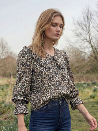 model wearing leopard blouse in countryside
