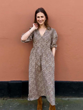 Model walking in The Ottilie Dress – leopard print dress in deadstock fabric, styled with tan boots.