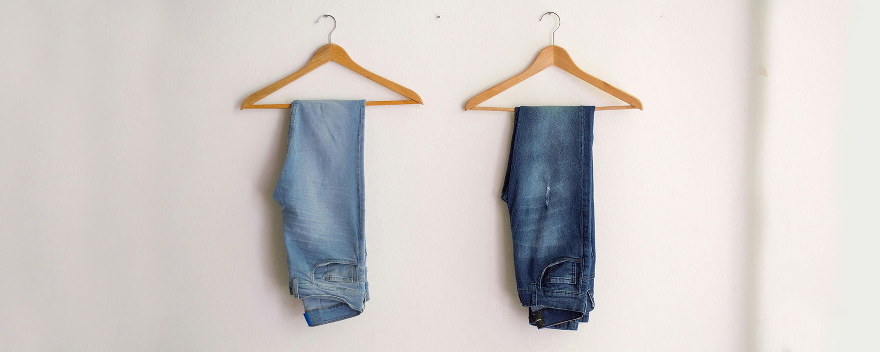 The Well Worn denim jeans on coat hangers on the wall