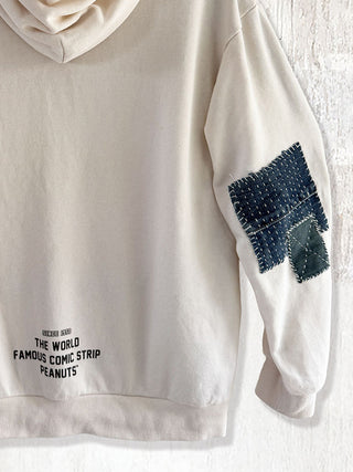 Beige hoodie with a patch and text on a white background