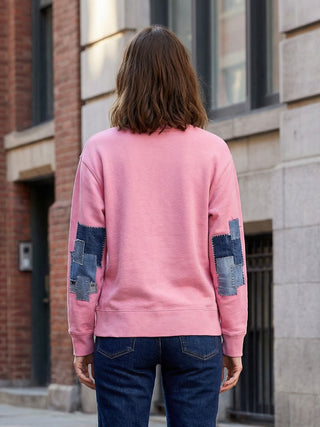 woman wearing denim patched sweatshirt in city