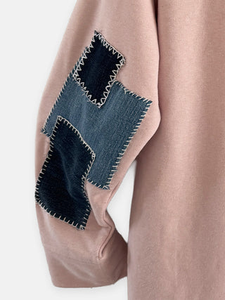 Close-up of a pink coat with denim patchwork on a white background