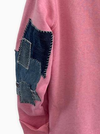 Pink sweatshirt with denim patch on a white background