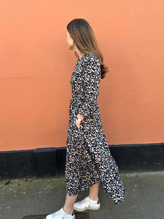 Sustainable floral print dress with ruffled sleeves and a flowing midi silhouette, made ethically in the UK.