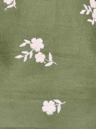 White floral pattern on a green fabric background