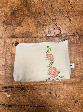 Small pouch with floral embroidery on a wooden surface