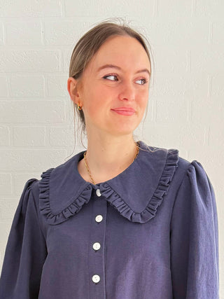 Slow fashion in action – model wearing structured navy blouse with full-length sleeves