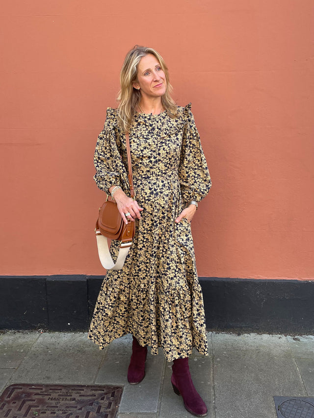 woman wearing navy gold floral dress