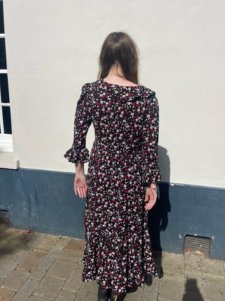 women wearing floral ruffle dress back view
