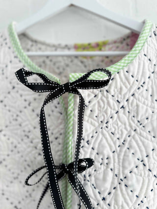 quilted waistcoat hanging on wall bow detail