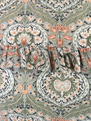Decorative pattern with floral and leaf designs in green, pink, and brown.