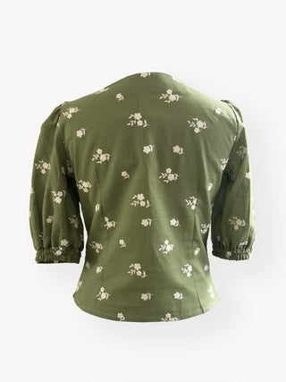 Green blouse with floral pattern on a white background