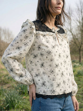 Woman wearing a floral blouse with lace details outdoors