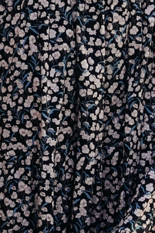 Floral patterned fabric with small flowers on a dark background