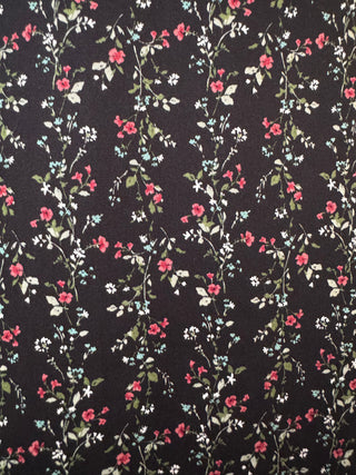 Floral patterned fabric with pink and white flowers on a black background